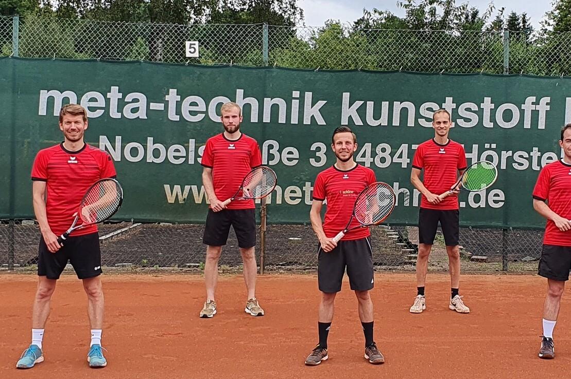 Sieben m&auml;nnliche Tennisspieler in roten Shirts stehen auf einem Tennisplatz, jeder bei sich haltend einen Schl&auml;ger.
