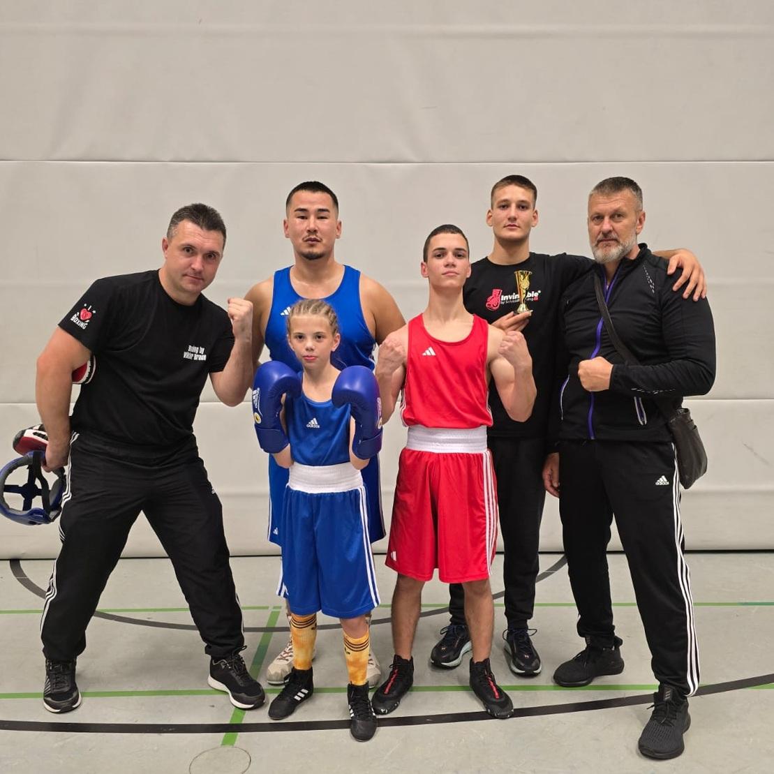 Gruppe von Boxern und Trainern nach Sparringkämpfen in Bad Oeynhausen, die stolz posieren.