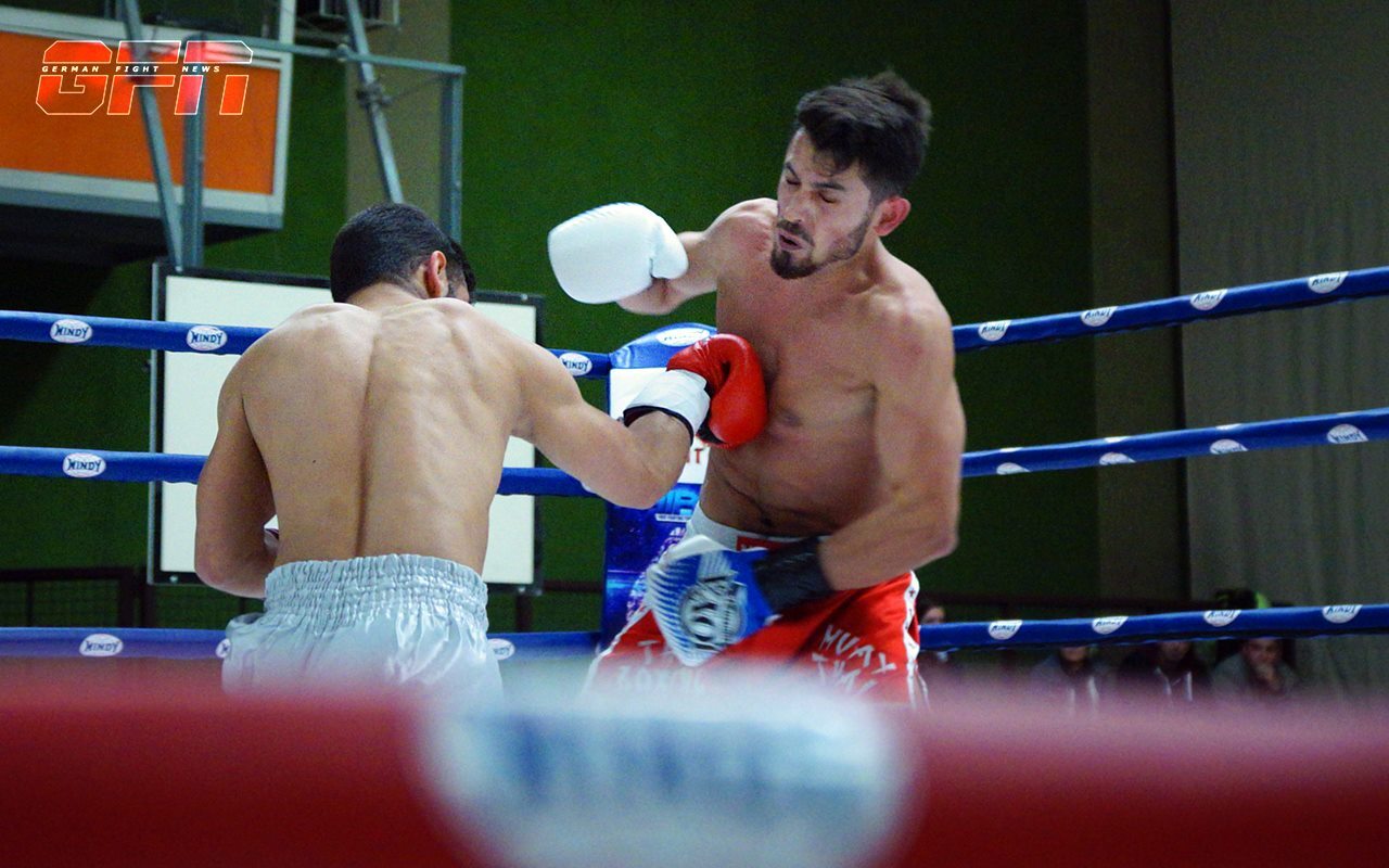 Zwei Boxer k&auml;mpfen im Ring, einer verpasst dem anderen einen Schlag mit der linken Hand.
