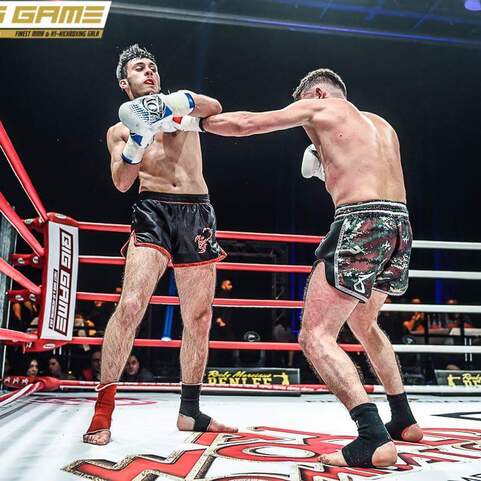 Zwei K&auml;mpfer im Ring w&auml;hrend eines Wettkampfs, einer trifft mit einem Schlag den anderen.