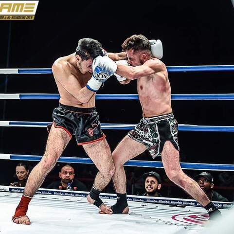 Zwei K&auml;mpfer im Ring, im Clinch, w&auml;hrend einer einen Schlag auf den Kopf des anderen ausf&uuml;hrt.