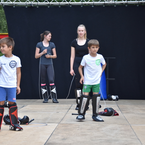 Kinder in Schutzausr&uuml;stung stehen auf einer Trainingsfl&auml;che, bereit f&uuml;r eine Kampfsport&uuml;bung.