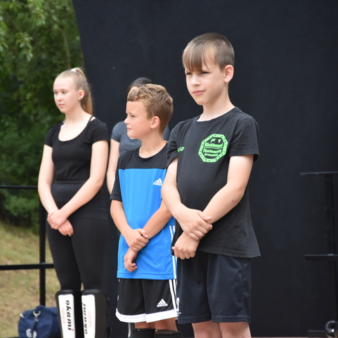Gruppe von Kindern in Sportkleidung steht auf einer Freifl&auml;che, bereit f&uuml;r eine &Uuml;bung oder Vorstellung.