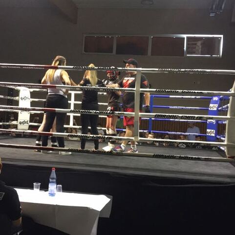 Zwei Boxerinnen stehen sich in einem Ringsetting gegen&uuml;ber, w&auml;hrend ein Schiedsrichter zwischen ihnen agiert.