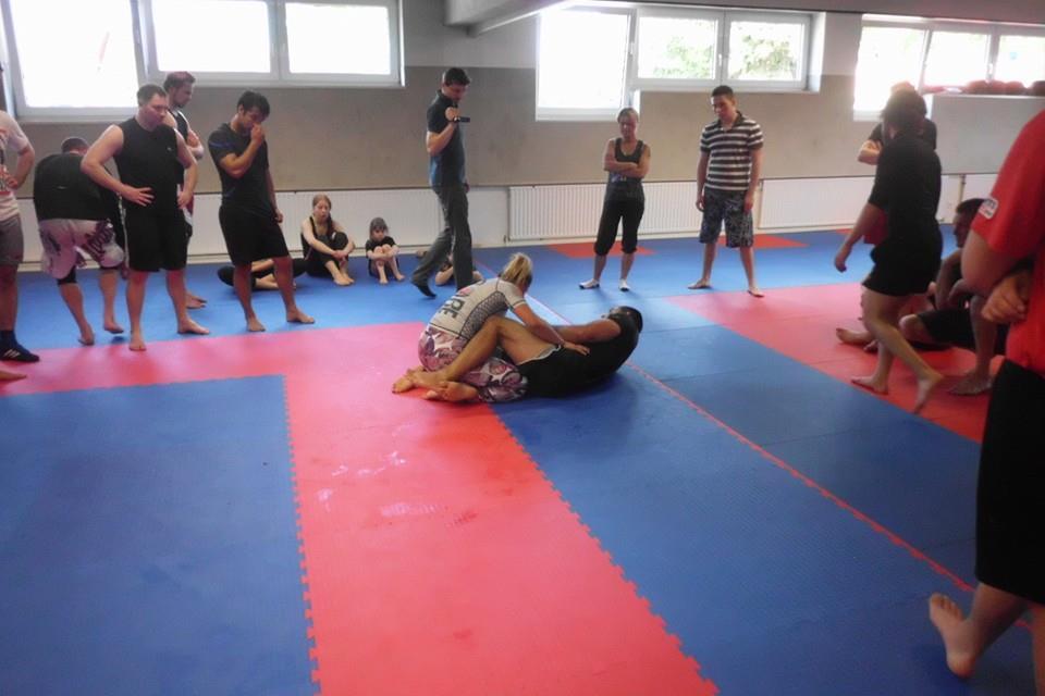 Gruppentraining im Kampfsport: Ein K&auml;mpfer wird am Boden von einer anderen Person in einer Haltegriff-Position kontrolliert.