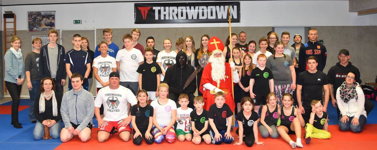 Gruppenfoto mit 40 Personen in Sportkleidung, darunter ein Nikolaus, auf einer blauen Trainingsfl&auml;che.