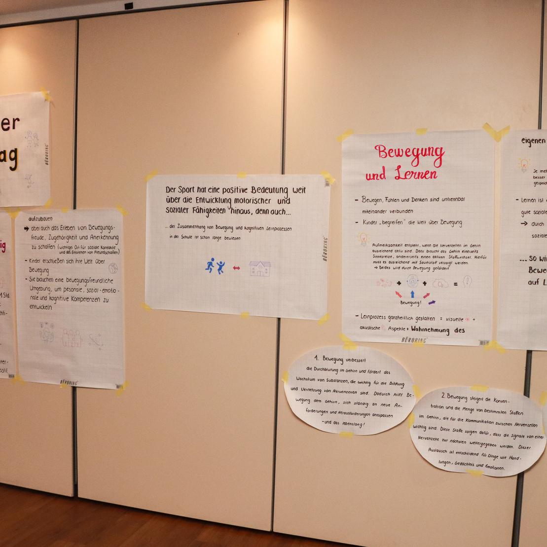 Wand mit Plakaten zum Thema &bdquo;Bewegter Ganztag&ldquo; und Informationen zu Bewegung, Lernen und ihrer Bedeutung f&uuml;r Kinder.