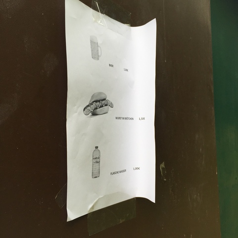 Preisliste auf einem Blatt Papier mit Getr&auml;nken und W&uuml;rstchen auf einer Wand befestigt.
