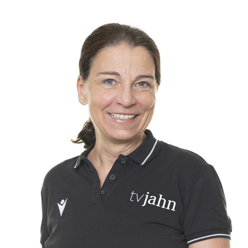 Frau mit kurzer, brauner Haarfrisur in schwarzer Poloshirt mit dem Logo „tvjahn“ vor weißem Hintergrund.