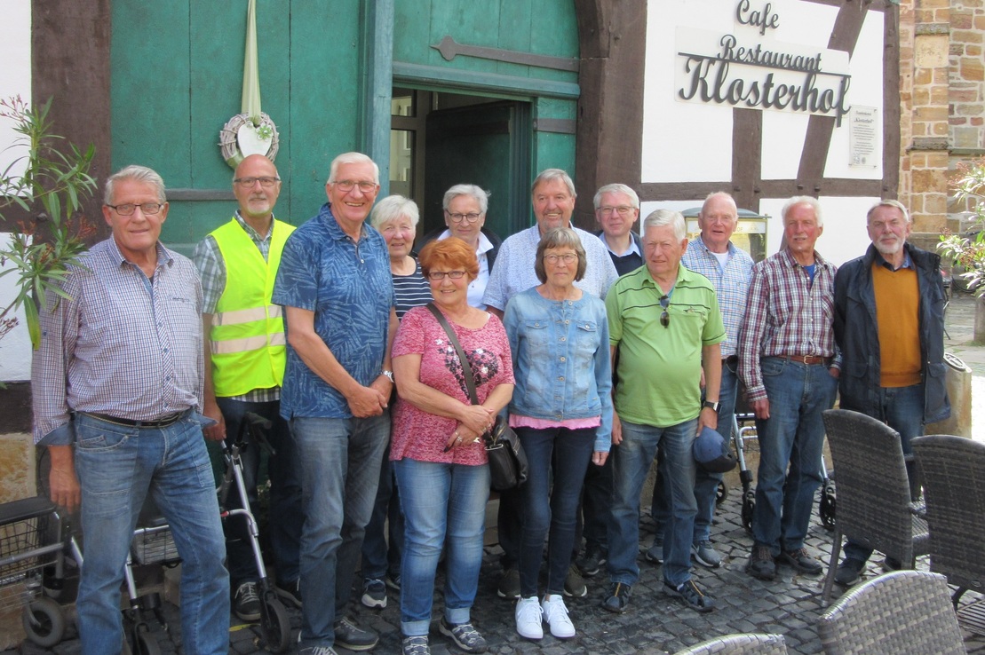 Gruppe von 14 Personen steht vor dem Caf&eacute; Restaurant Klosterhof, umgeben von Tischen und Pflanzen.