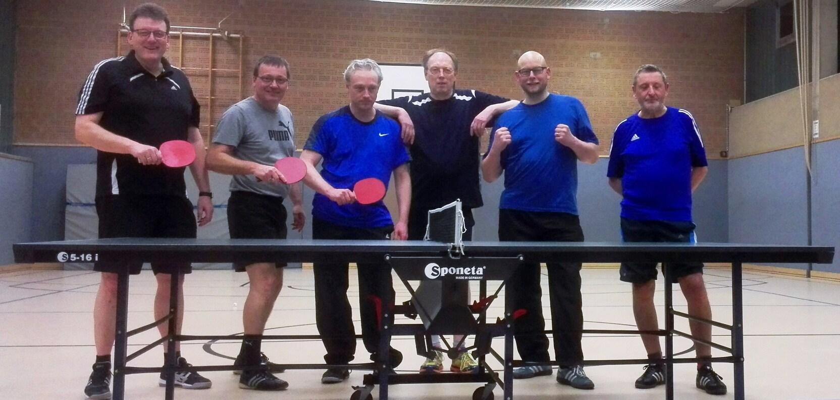 Sechs M&auml;nner stehen an einem Tischtennistisch, jeder h&auml;lt einen pinken Tischtennisschl&auml;ger in der Hand.